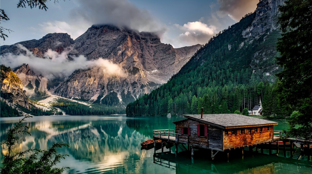 Cabane à vendre au bord d'un lac de montagne, sous le ciel bleu en journée.