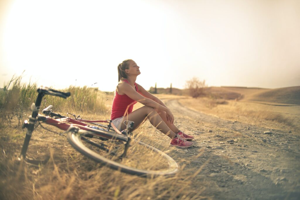 Femme dans la nature avec son vélo rouge