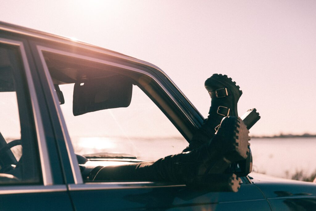 Faire une pause en voiture au bord de la mer, les pieds à la fenêtre